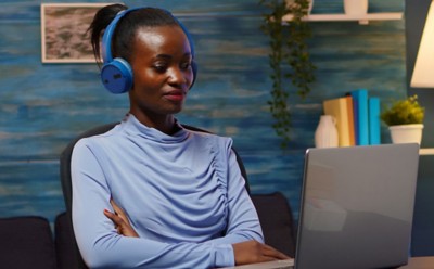 woman at laptop in home office using headphones