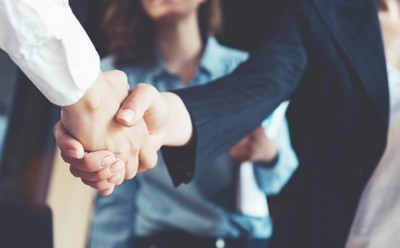 Business people shaking hands, representing Expert Support for Assure Risk Management | DXC Technology Capabilities
