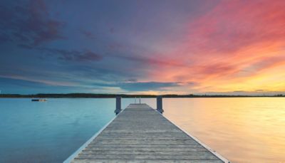Pier leading out to the ocean, with colorful sky, Cloud Platforms | DXC Technology