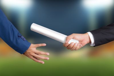 person passing baton to another, representing business continuity as organizations transition to Windows 11 | DXC Technology