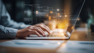 Business professional analyzing data on laptop, representing enterprise data management in financial services | DXC Technology