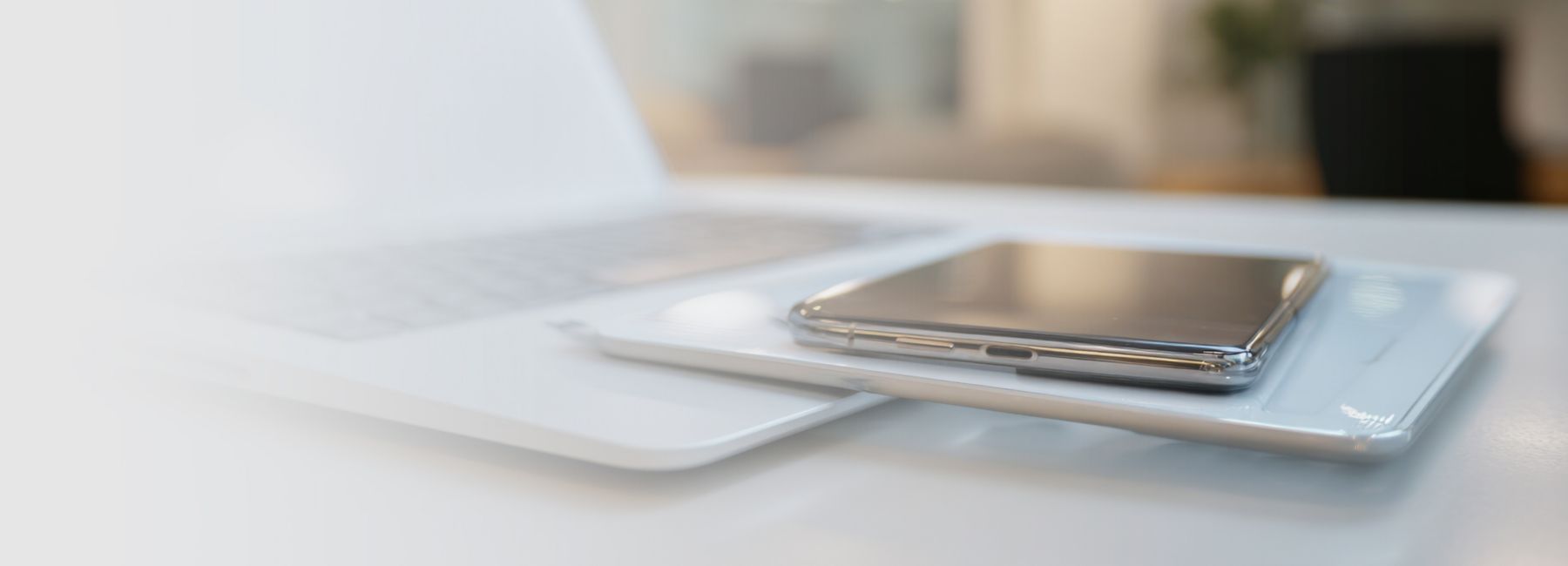 Laptop and Smartphone on a table representing platform-as-a-service solution for financial services | DXC Technology