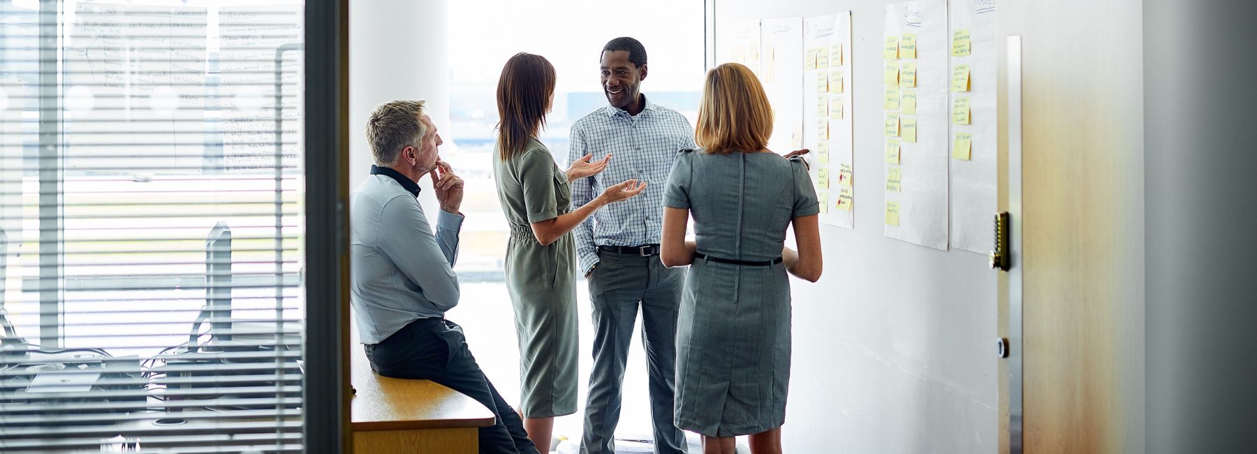 Financial managers reviewing business results in a meeting room, Economics of AI | DXC Technology Insights