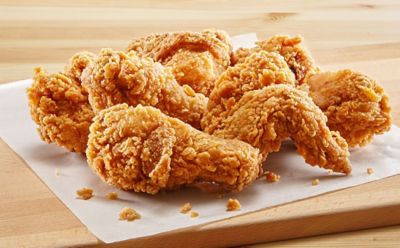 Crispy fried chicken fingers on a white cloth on top of a wooden cutting board, Jollibee Foods | DXC Technology Customer Story