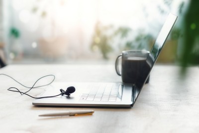 Home education or work outside office concept. Laptop with a microphone and cup of coffee on the table