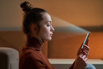 Woman using biometric facial scan for secure identity and access management verification, Zero trust solutions | DXC Technology