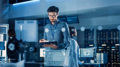 Engineer using tablet in a computer lab, Modernization and Simplification, Financial Services | DXC Technology