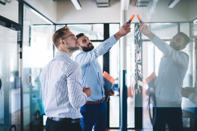Two consultants discussing strategy by white board, Snowflake AI Data Cloud | DXC Technology