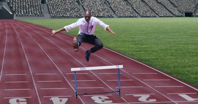 Businessman jumps over hurdles on track in stadium, Modern Device Management | DXC Technology Insights