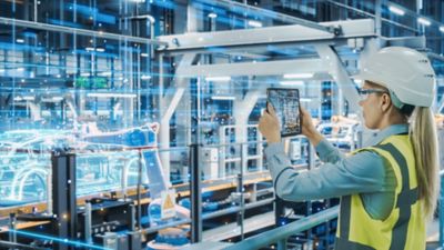 Person using tablet on manufacturing line, Manufacturing | DXC Technology Insights