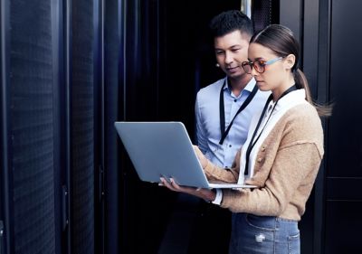 Consultants Working on Laptop in Data Center: Tailored Tech Solutions & Compliance, Cybersecurity | DXC Technology
