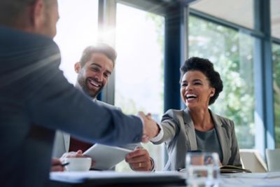 Office workers shaking hands, representing VMware Cloud Service provider partnership | DXC Technology
