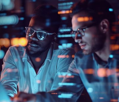 Two male software engineers reviewing code on a screen, Consulting & Engineering Services | DXC Technology 
