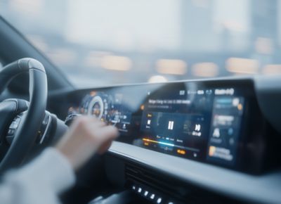Hand resting on interior vehicle digital display, Software-defined vehicle platform | DXC Technology