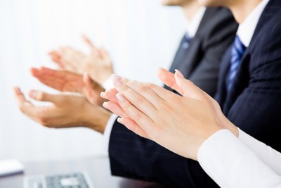 Close up clapping hands of businesspeople at presentation, meeting, seminar or conference