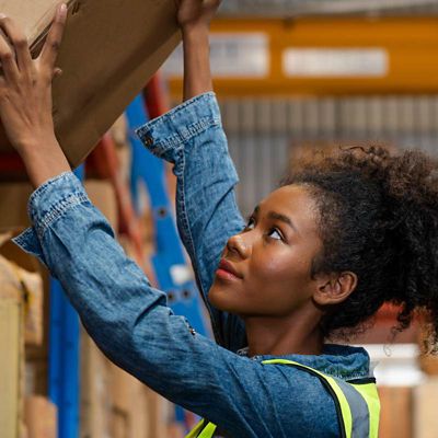 woman taking cardboard box off of a shelf