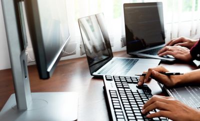 hands typing on laptops and keyboards, Cloud & Infrastructure | DXC Technology Customer Story