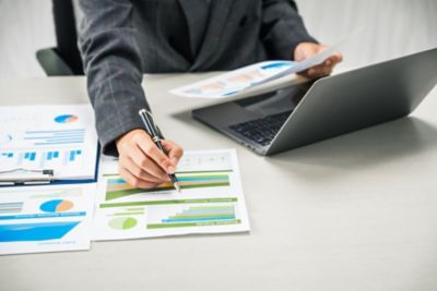 A businesswoman reviewing financial documents and analyzing data, Market Infrastructure, Financial Services | DXC Technology