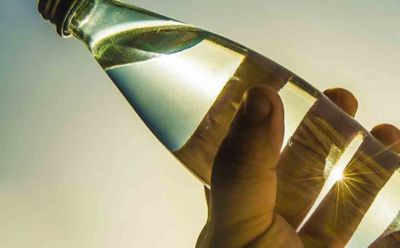 close-up of a tilted glass bottle with clear liquid