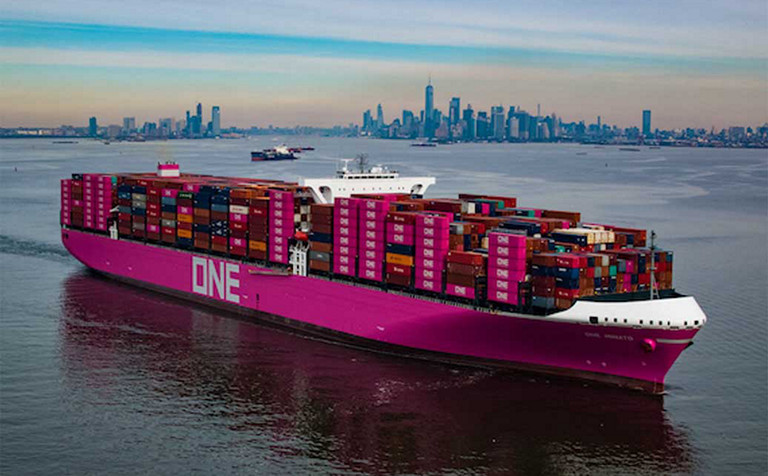 large pink ONE ship with containers in a harbor