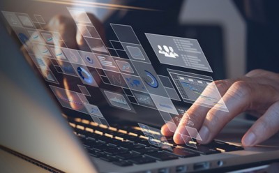 Hands on a keyboard with automation overlay, Data-driven intelligent automation for "silent operations" | DXC Technology