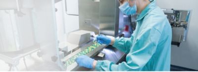 Lab technician in lab coat holding tongs, doing quality checks on medication, Regulatory Automation Software | DXC Technology