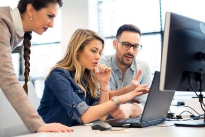 Three executives discussing business applications at laptop, Apps Modernization Services for Google Cloud | DXC Technology