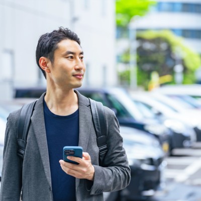 Man standing by parked cars - Demonstrating AI’s impact by starting small and thinking big | DXC Technology Insights
