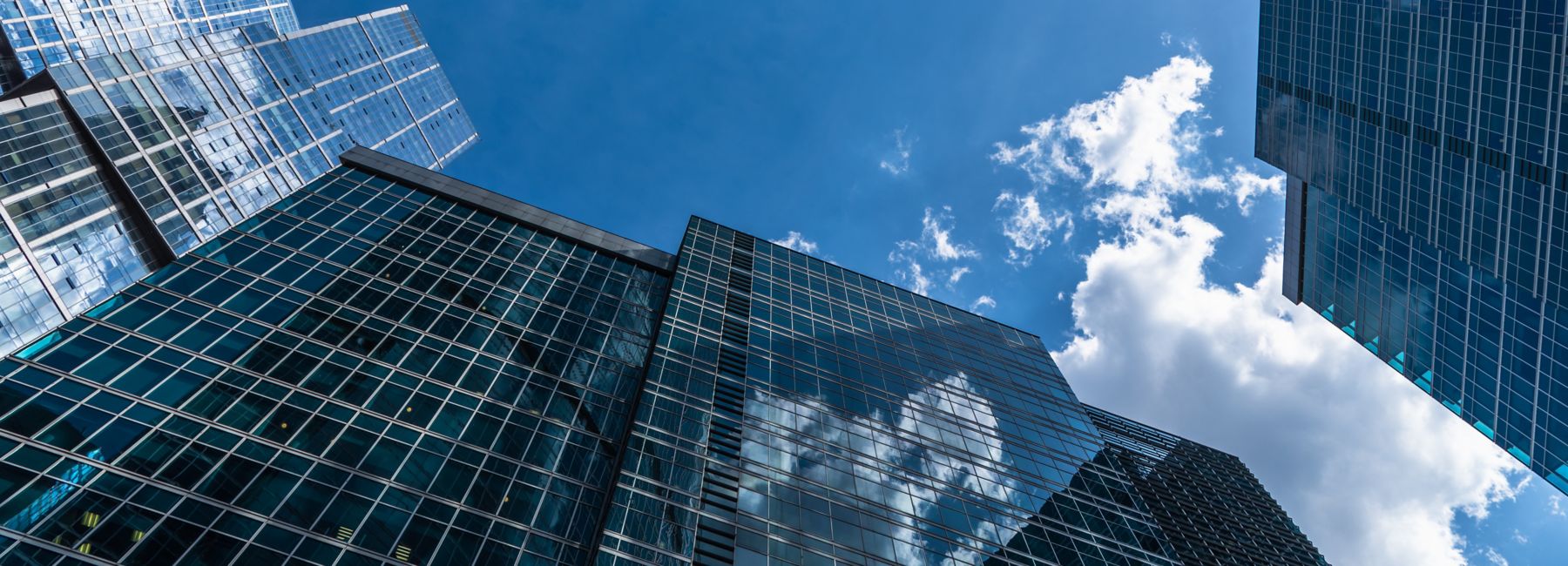 multiple office buildings against bright cloudy sky, Cloud & Infrastructure | DXC Technology Insights