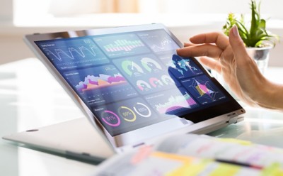 Hand at a colorful tablet screen, scrolling through data charts and analytics, Data & AI | DXC Technology