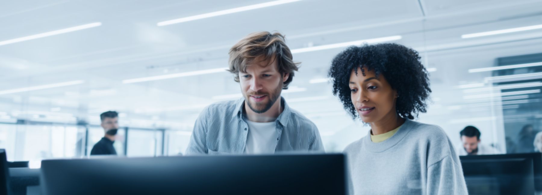 Colleagues collaborating at office computer, Private AI | DXC Technology Insights