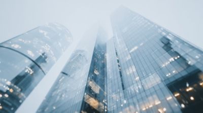 Skyscrapers with financial graphs and numbers overlay, Corporate Treasury, Financial Services | DXC Technology