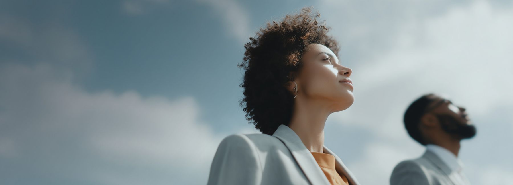 Diverse man and woman looking upwards to bright sky, Dynatrace Business Observability report | DXC Technology