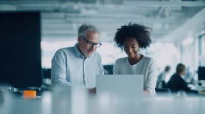 People working on notebook representing Hogan Academy,  Hogan Core Banking Platform | DXC Technology Platforms