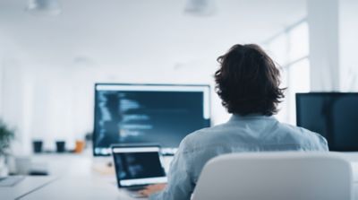 Software developer coding representing end-to-end Hogan testing services, Hogan Core Banking Platform | DXC Technology Platforms