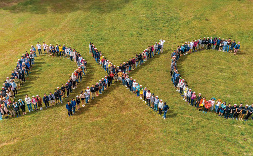 people standing to form the letters DXC
