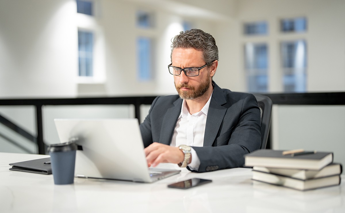Business man using computer in office representing Operational Excellence Advisory Services | DXC Technology
