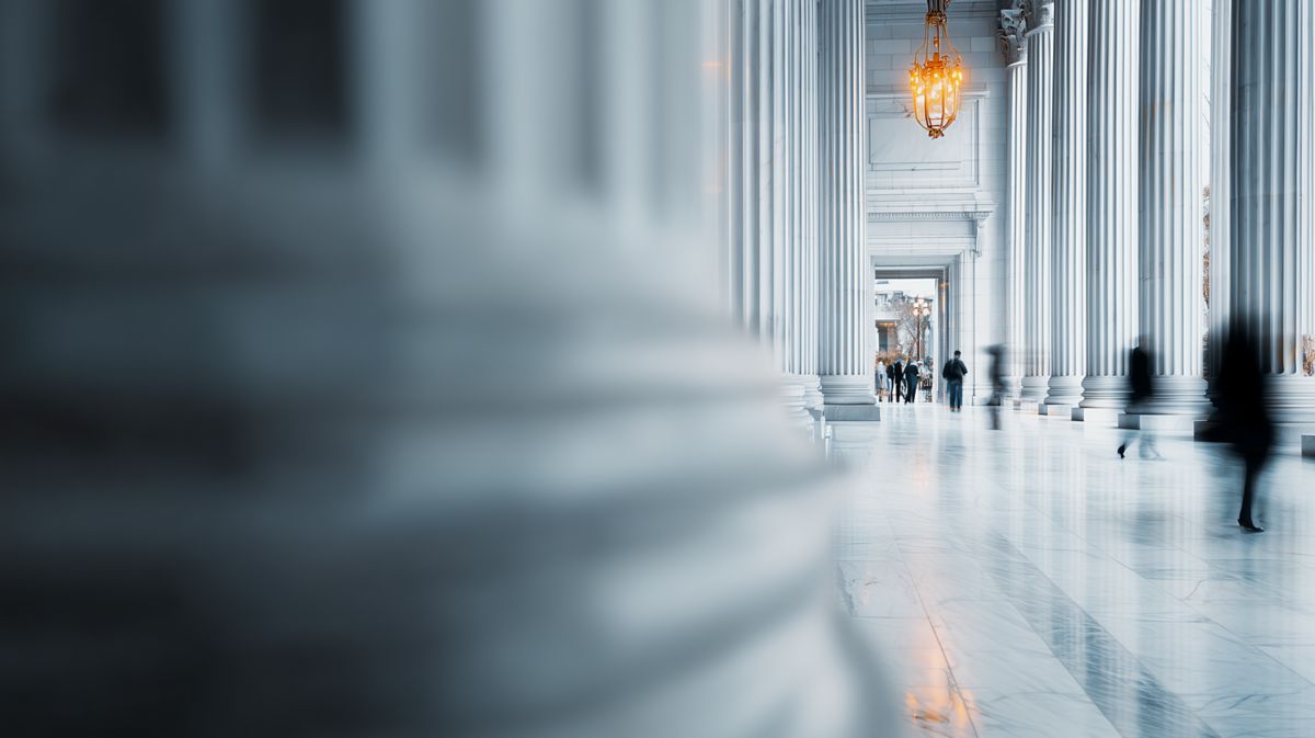 Colonnade hallway with blurred people walking – business process service for banking and financial institutions