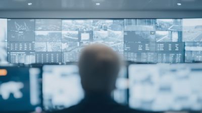 Professional analyzing data on laptop, representing a government AI sovereign cybersecurity solution | DXC Technology