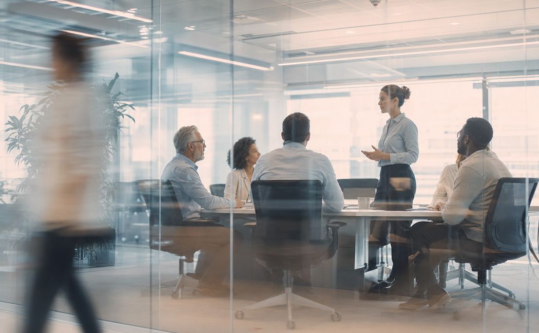 Team meeting on business process services for finance & accounting in a glass-walled office | DXC Technology