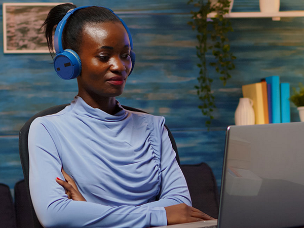 woman at laptop in home office using headphones