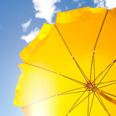 yellow beach umbrella in sunny sky