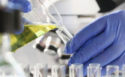 A male chemist holds test tube of glass in his hand