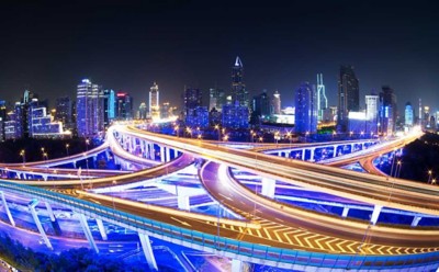 illuminated traffic on elevated expressway in modern city.